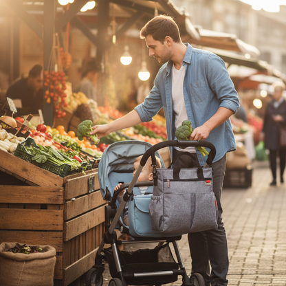 Papa avec bébé au marché public avec le sac à langer gris accrocher à la poussette