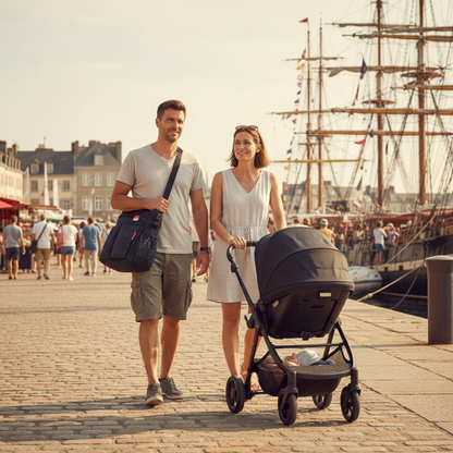 Papa porte le sac en bandoulière, maman à ces côté pousse la poussette de bébé sur les quais lors de la Fêtes maritimes de Brest 